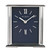 A rectangular mantel clock with a dark blue face, silver-toned hands, and silver-toned Roman numerals at the twelve and six o'clock positions. The clock features a metallic silver frame with vertical ribbed detailing and the text Wm. Widdop.