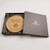 A wooden circular charcuterie board. Made from rubberwood with sliding opening lid to reveal 3 cheese servers. Customised text on top of lid with engraved stunning cheese and grapes design. Sitting in a luxury grey gift box