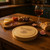 A wooden circular charcuterie board. Made from rubberwood with sliding opening lid to reveal 3 cheese servers. Customised text on top of lid with engraved stunning cheese and grapes design.