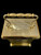 A gold plated carriage clock with easy to read roman numerials. Customised engraved message plate on top. Easy comfortable grip handle