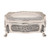 A rectangular silver-toned metal jewellery box featuring a smooth, reflective lid and sides decorated with intricate, raised scrollwork patterns. The box is supported by four ornate, curved legs with detailed engravings.