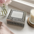 Silver small keepsake box with an ornate design with personalised inscription on lid. Dispalyed near a window in lifestyle home setting.