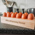 A rectangular egg tray holding 12 eggs on a black marble kitchen counter top.