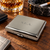 A rectangular, polished silver-tone metal cigarette case featuring a smooth, reflective surface with the engraved letters S.E.A. centred on the top lid. The case has a secure latch mechanism on the front edge and rounded corners.