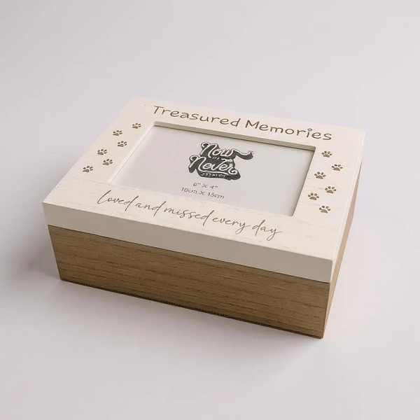 A rectangular wooden pet photo memory box. 2 tone white and brown wood. Printed with paw prints either side of 6x4 photograph window and sentimental message printed above and below.