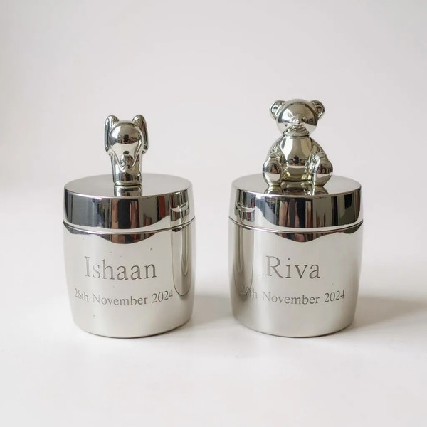 A matching pair of silver baby first tooth and curl gift set. Stunning elephant icon on 1 box and matching teddy bear on the other. Customised text engraved on the front of each box.