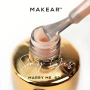 Close-up of a gel polish brush applying a delicate semi-transparent nude shade to a nail sample. The image highlights the creamy texture, soft pink-beige appearance and controlled application associated with Makear 620 Marry Me Hybrid Gel Polish.