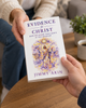 One adult giving Evidence for Christ by Jimmy Akin to another person, with the book cover clearly visible.