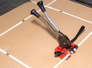 Strapping tool being used to strap cardboard