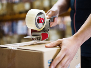 Tape gun being used to seal box