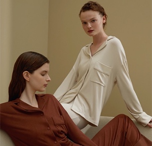 Woman in white loungewear sitting next to woman in maroon loungewear