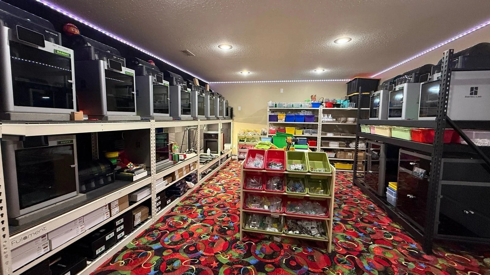 The SFL Designs print farm: rows of named Bambu printers and parts bins