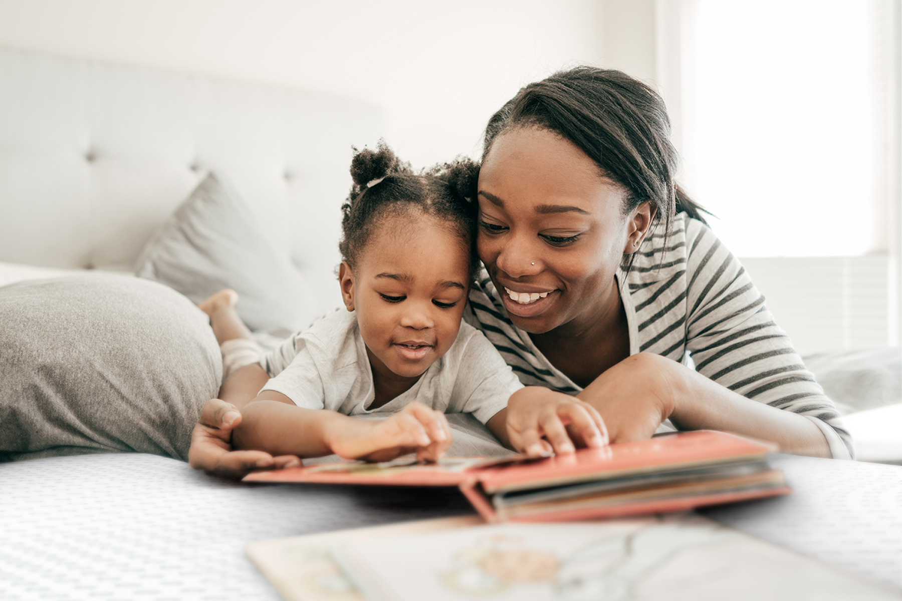 Woman and child reading a book on a DwellSleep mattress 