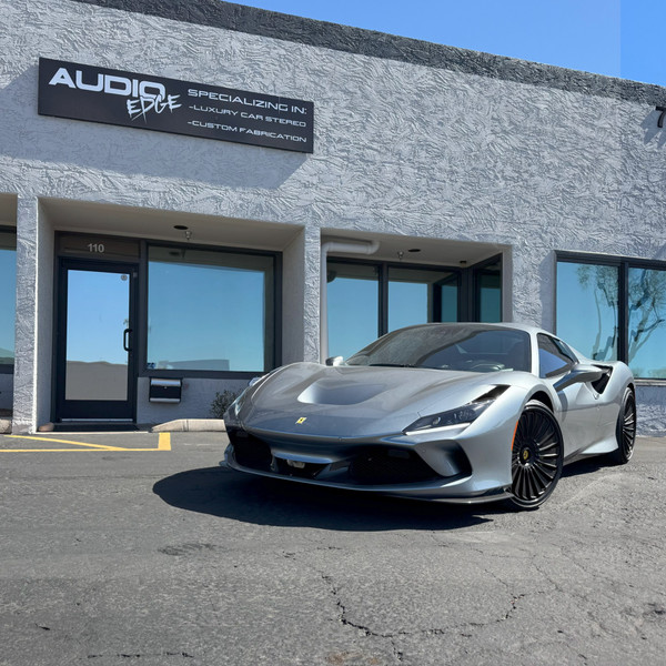 Silver 2021 Ferrari F8 parked in front of the Audio Edge shop in Scottsdale