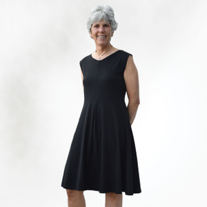 Front view of model wearing black solid color organic cotton Box Pleat Dress. Front view of model wearing black solid color organic cotton Box Pleat Dress.