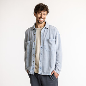 Front view of model wearing organic cotton workwear shirt in color denim blue