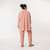 Full body back view of model wearing organic cotton button down shirt in color blush. Full body back view of model wearing organic cotton button down shirt in color blush.