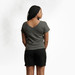 Model wearing heather grey solid color organic cotton T shirt with a boat neckline shown from the back.