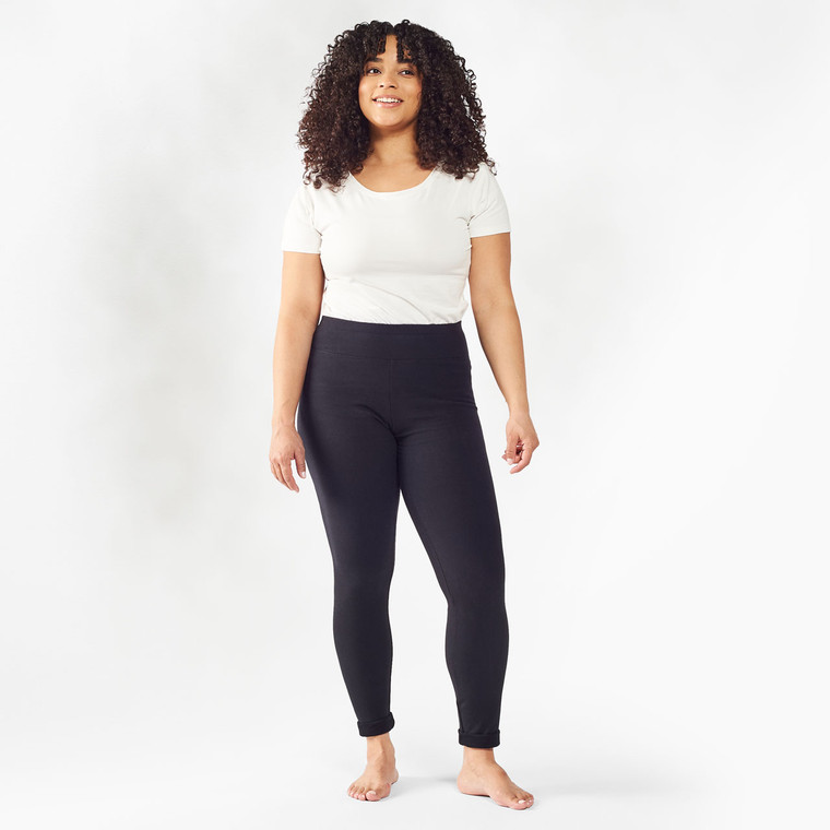 Model wearing black solid color organic cotton fleece leggings.
