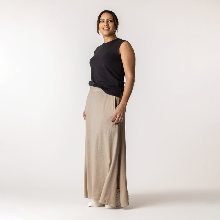 Full body front view of model wearing organic cotton maxi skirt in putty.