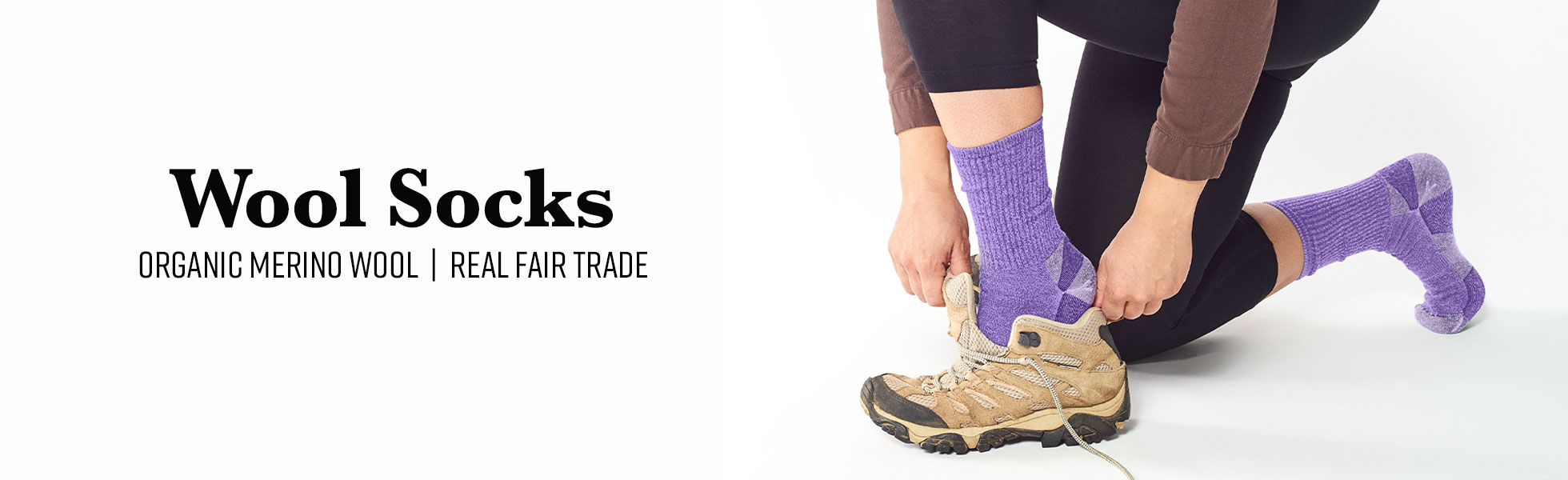  Person putting on shoes wearing Purple Urban Hiker socks. Text Next to them reads: Wool Socks Organic Merino Wool Real Fair Trade.