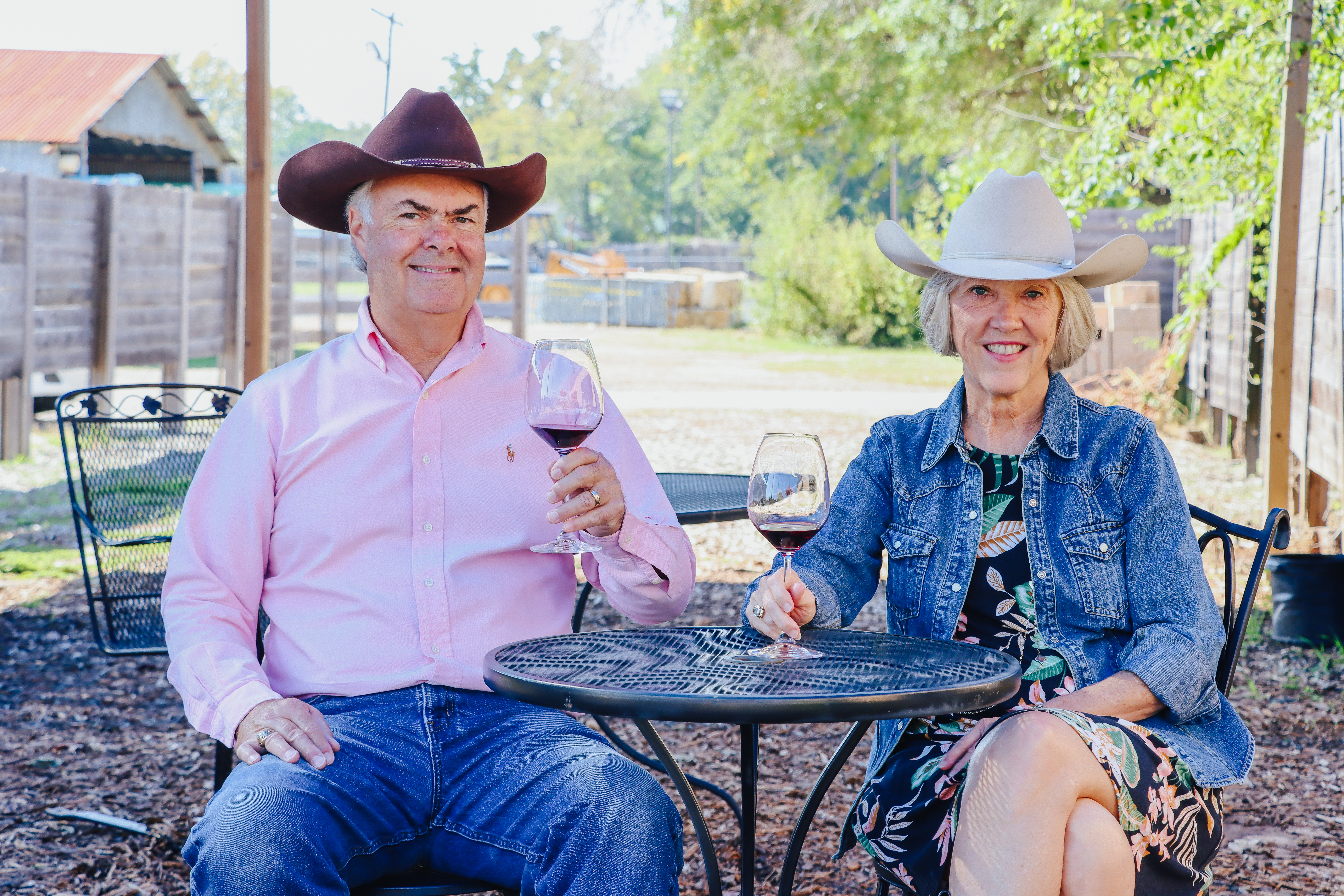 Joe and Anne Moody sitting outside with cowboy hats