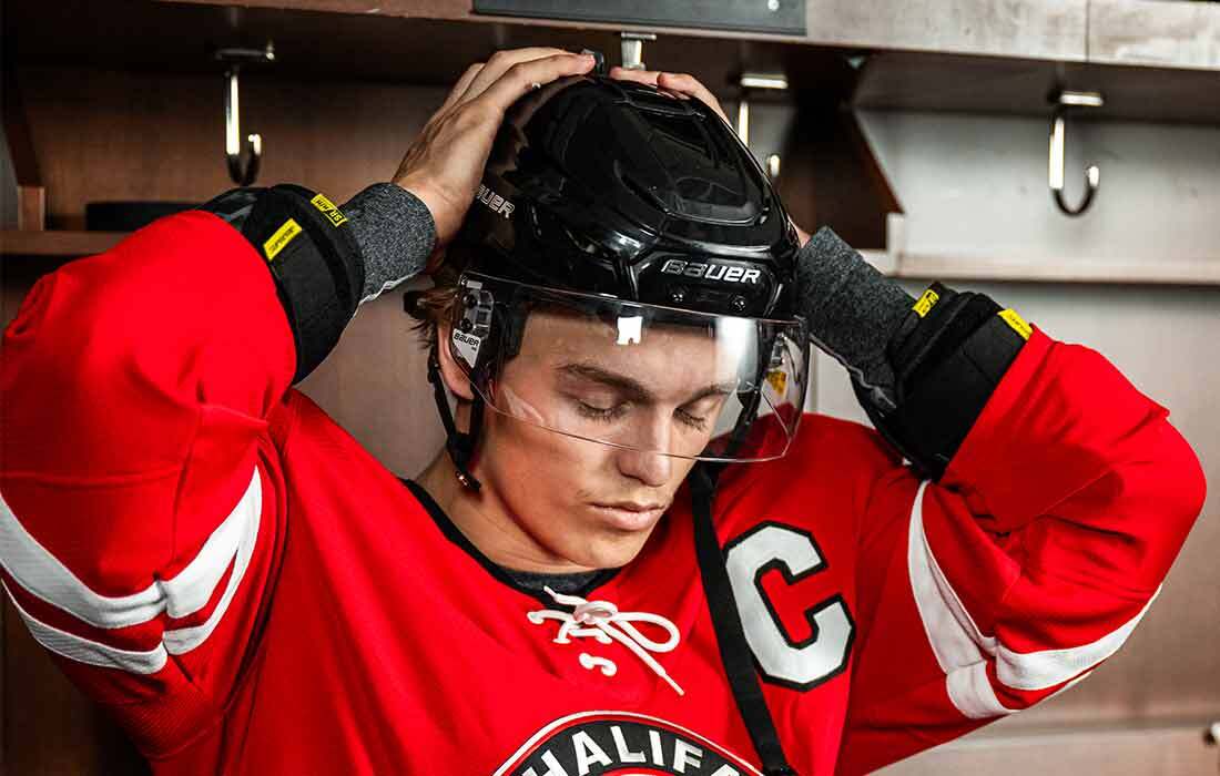 Hockey player putting a helmet on