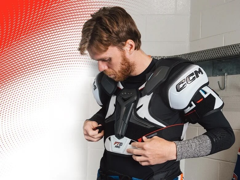Hoeckey player putting shoulder pads on