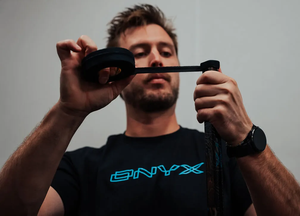 Player taping a hockey stick blade with fresh tape
