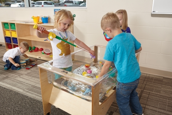 Three kids at water sensory table