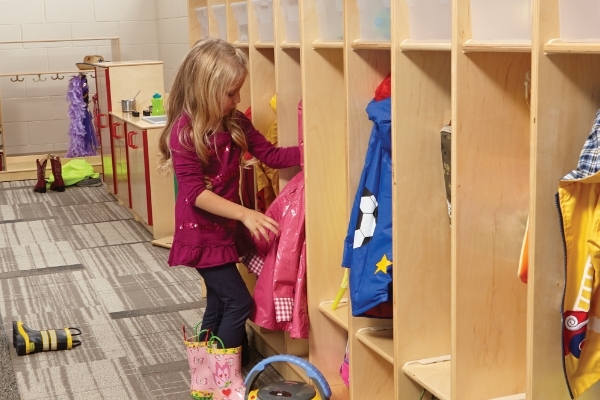 Girl putting jacket into locker space