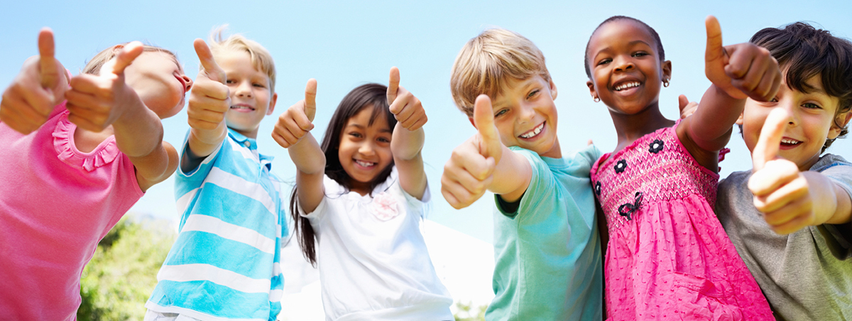 Young kids looking at camera, smiling, with thumbs up