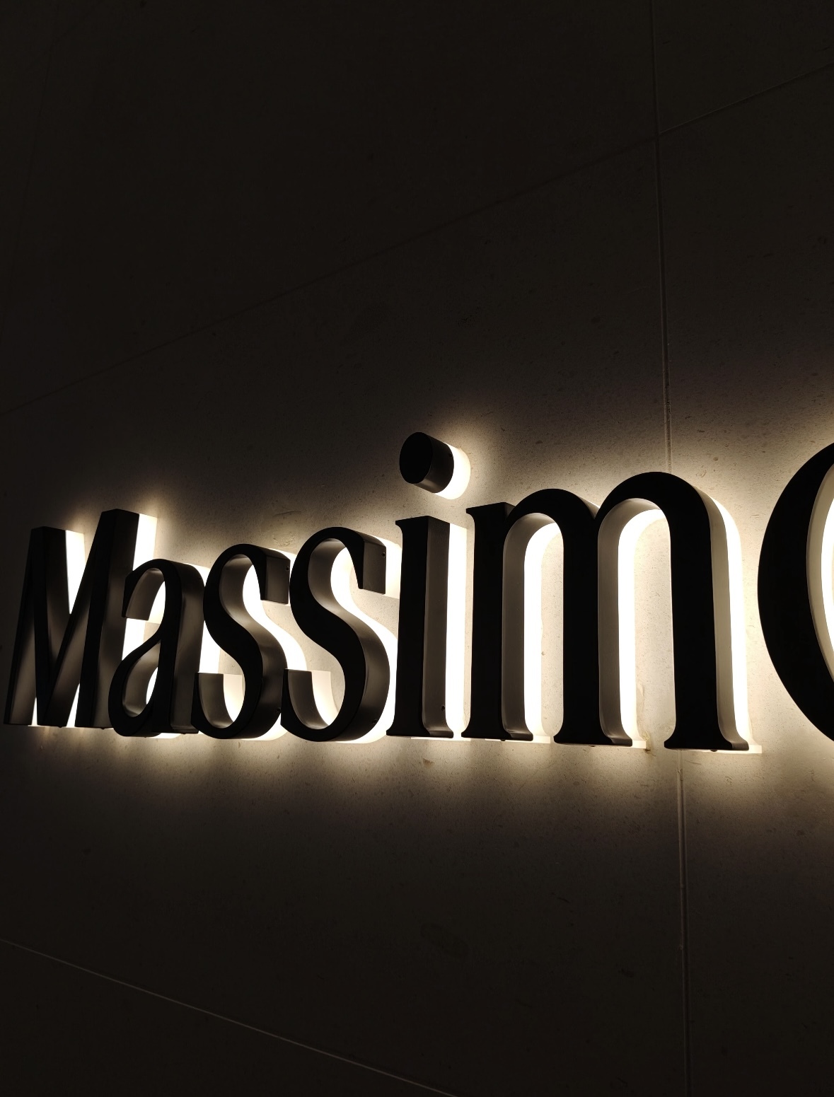 Backlit channel letters close‑up, stainless steel business logo