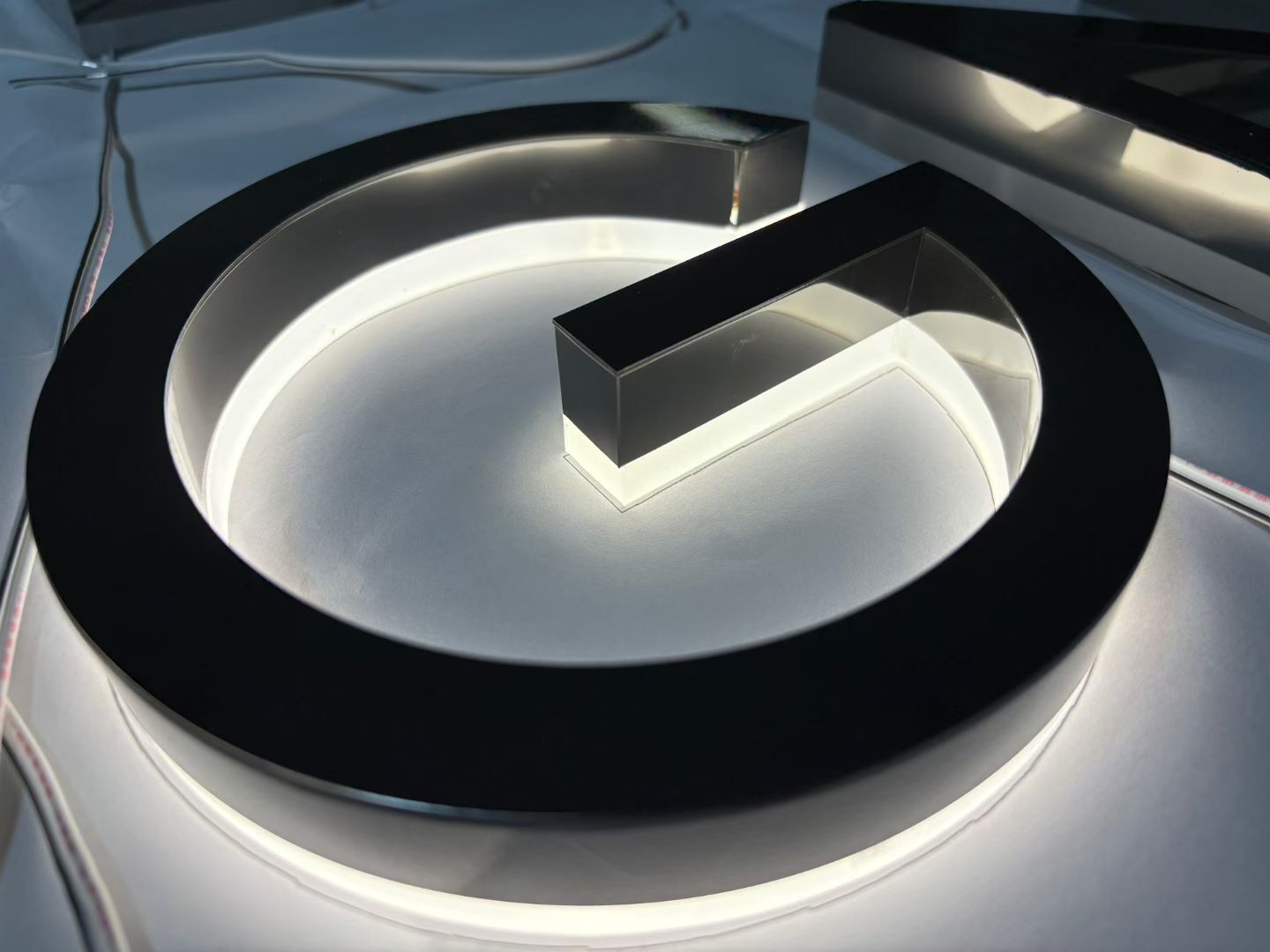 Backlit stainless steel round logo prototype