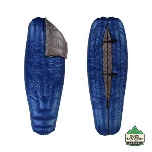 Two views of the navy blue Enlightened Equipment Revelation Sleeping Quilt with charcoal gray interior, showing the open hood on the left and the adjustable zippered footbox on the right, with a "2025 Top Gear on the AT" badge from The Trek.
