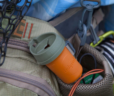 Small cylindrical trash can like object hooked onto the loops of someone's fly fishing gear