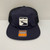 Front view of solid navy trucker hat. RRT logo in the center. Front view of solid navy trucker hat. RRT logo in the center.