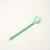 shows long handled spork with polished bowl and a green color