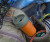 Small cylindrical trash can like object hooked onto the loops of someone's fly fishing gear