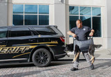 Dog in a Quiklitter K9 being carried by a deputy