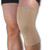 A woman wearing a medical-grade tubular sleeve for knee support in the beige colour.