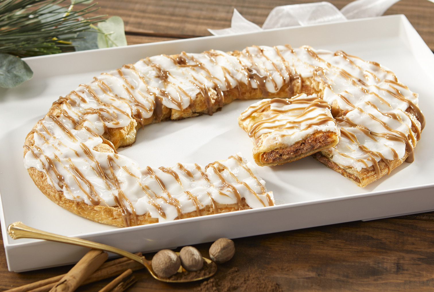 Gingerbread Kringle on a white plate with a piece cut out.