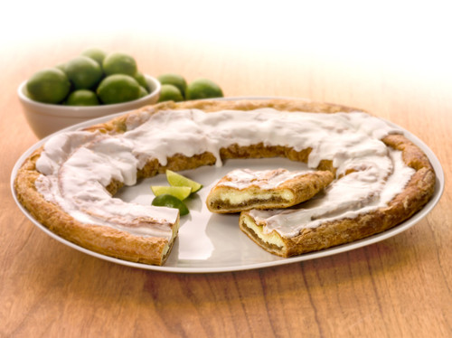 Key Lime Kringle on a white plate with slices of limes and bowl of limes.