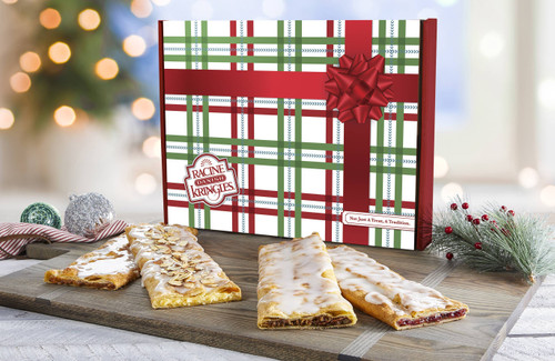 The Classic Stick Sampler in a Holiday Box with Kringles in front of the box on a wooden cutting board.