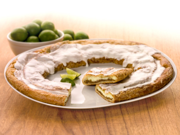 Key Lime Kringle on a white plate with slices of limes and bowl of limes.