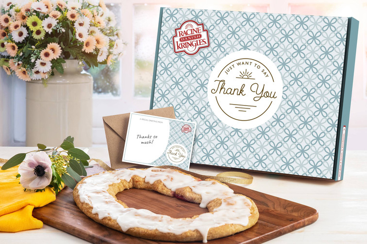 Thank You Gift Box with a Kringle sitting on a wooden cutting board in front of the box.