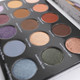 a close up of green, gold, and blue eyeshadows in a palette