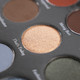 a close up of a gold eyeshadow in a palette
