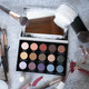 an open eyeshadow palette surrounded by other cosmetic and beauty items.