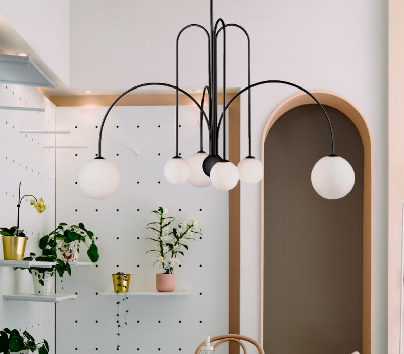 Comet Chandelier by Artcraft styled in a bohemian styled dining room with plants on white shelves and wallls.